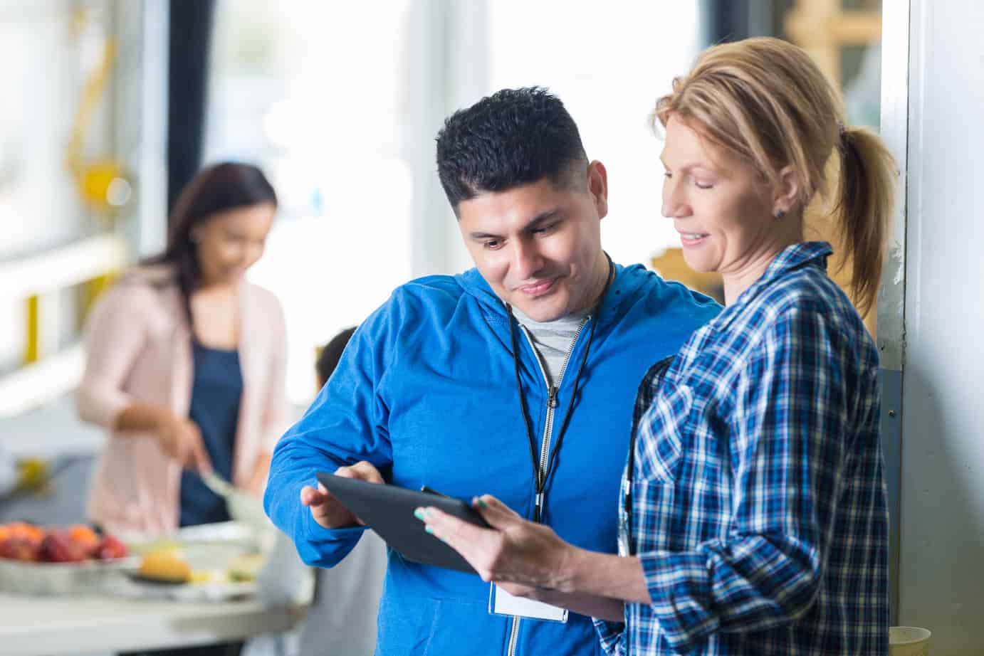Volunteers using digital tablet in charity food bank